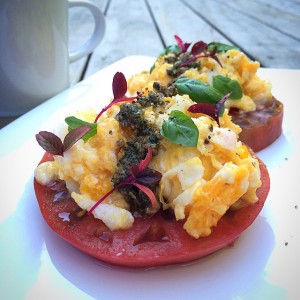 Beefsteak tomatoes toped with scrambled eggs and pesto